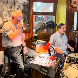 Two musicians sit behind drums and play desk with microphones at Katie Dalys Limerick